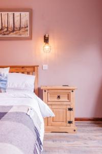 a bedroom with a bed and a wooden nightstand at Stables Wem in Wem