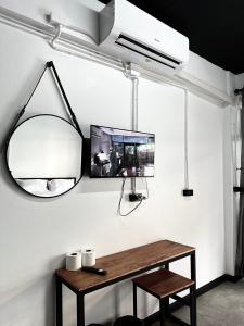a room with a table and a mirror and a fish tank at Sleep Owl Jomtien in Jomtien Beach