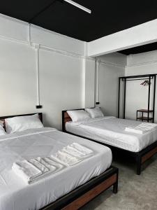 two beds sitting next to each other in a room at Sleep Owl Jomtien in Jomtien Beach