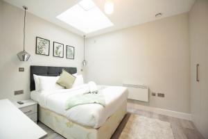 a bedroom with a large white bed and a skylight at Elm House in Reading +16 photos