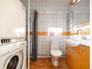 a bathroom with a toilet and a sink and a washing machine at Charming penthouse in the center of Visby in Visby