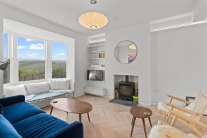 a living room with a blue couch and a fireplace at 1 Avonside, Bantham with sea views in Bantham