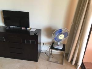 ein Zimmer mit einem Fernseher und einem Ventilator neben einer Kommode in der Unterkunft 3 Bedroom Apartment, Duquesa, Spain in San Luis de Sabinillas