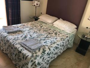 ein Schlafzimmer mit einem Bett mit einer Decke und Kissen in der Unterkunft 3 Bedroom Apartment, Duquesa, Spain in San Luis de Sabinillas