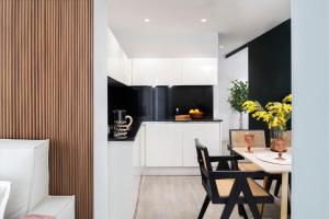 a kitchen with white cabinets and a table with chairs at Apartamentos Sevilla Centro in Seville