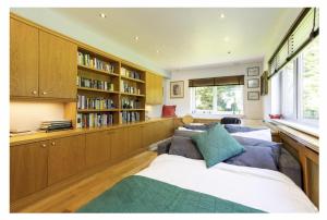 a living room with a couch and a book shelf at Sleeps10 18-Parking-Garden-Pool-HotTub-Balcony in Eastbourne
