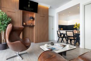 セビリアにあるアパルタメントス セビリア セントロの椅子とテーブルのあるリビングルーム