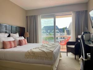 a bedroom with a large bed and a large window at Hôtel BO & MIA in La Baule