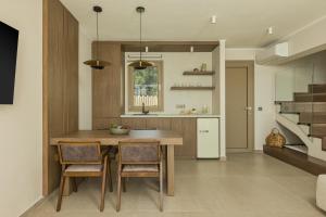 a kitchen with a wooden table and chairs at Scarabeo Suites & Villas Parga in Parga