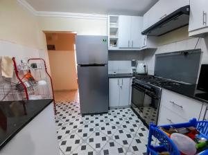 a kitchen with a stainless steel refrigerator and a tile floor at Milimani Luxury Apartments - J1 in Nakuru
