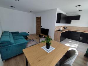 a living room with a table and a green couch at Mieszkanie 11 Listopada in Konin