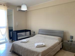 a bedroom with a bed with two towels on it at Casa Residence Canalotto in Realmonte