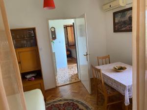 a dining room with a table and a door to a kitchen at Zelenica Apartment in Zelenika