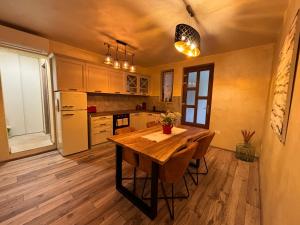 ラバックにあるAmor, flat with private hot tub, breathtaking views and free parking in a garage, bookable all year round, Also take a look at our flat Coccolinaの木製のテーブルと冷蔵庫のあるキッチン