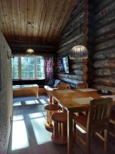 a dining room with a wooden table and chairs at Lomaruka in Ruka