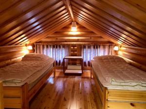 a bedroom with two beds in a wooden cabin at Villa Rukan Honka in Ruka