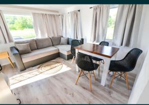 a living room with a couch and a table and chairs at Domek na Roztoczu - Jacuzzi in Krasnobród