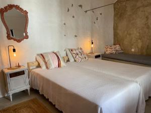 Un dormitorio con una gran cama blanca y un espejo. en Casal da Lapa, en Lapa 44 fotos más