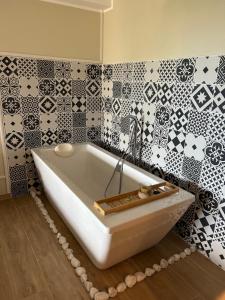a bath tub in a bathroom with black and white tiles at Chambre de charme Andria jacuzzi in Patrimonio