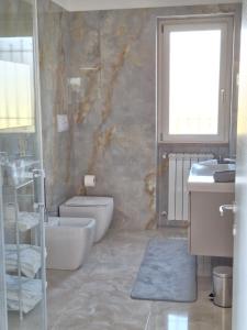 Un baño con inodoro, lavabo y ventana. en Mimì Luxury Apartment, en Pompeya
