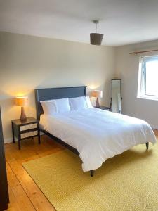 a bedroom with a large bed and a window at Lilac Lodge - Strandhill Beach House in Strandhill