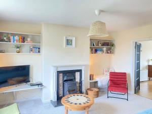 a living room with a fireplace and a red chair at Lilac Lodge - Strandhill Beach House in Strandhill
