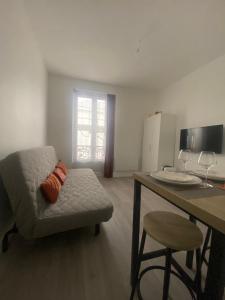 ein Wohnzimmer mit Sofa und Tisch in der Unterkunft Appartement près Paris & Disney in Le Perreux-sur-Marne