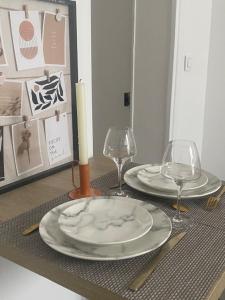einen Tisch mit 2 Tellern, eine Kerze und eine Brille in der Unterkunft Appartement près Paris & Disney in Le Perreux-sur-Marne + 34 Fotos