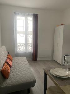 ein Wohnzimmer mit Sofa und Tisch in der Unterkunft Appartement près Paris & Disney in Le Perreux-sur-Marne