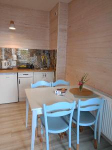 una cucina con tavolo e alcune sedie blu di Rybacki Domek 50 metrów do morza! a Dziwnów