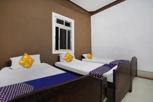 - 3 lits dans une chambre avec fenêtre dans l'établissement SPOT ON Hotel Sunrise, à Chandrapur
