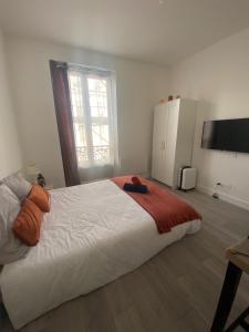 ein Schlafzimmer mit einem großen weißen Bett und einem Fenster in der Unterkunft Appartement près Paris & Disney in Le Perreux-sur-Marne