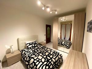 a bedroom with a black and white bed and a mirror at Casa Luelda in San Maurizio Canavese