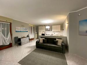 a living room with a couch and a kitchen at Casa Luelda in San Maurizio Canavese