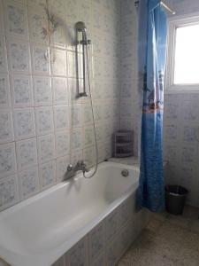 a white bath tub in a bathroom with a window at apparemment pied dans leau in Korba