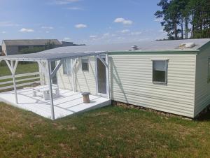 a mobile home with a porch and a roof at GreenKris in Ostaszewo