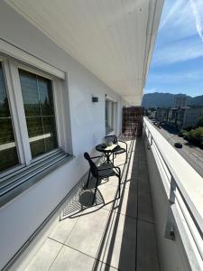 a balcony with two chairs and a table on it at rs44 Apartments über den Dächern von Bregenz in Bregenz