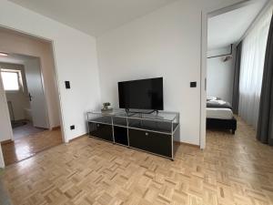a living room with a flat screen tv on a dresser at rs44 Apartments über den Dächern von Bregenz in Bregenz