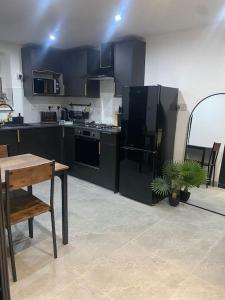 a kitchen with black cabinets and a table with a plant at The Courtyard - By Casa Living in Canley