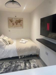 a bedroom with a bed and a flat screen tv at The Courtyard - By Casa Living in Canley