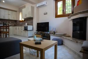 a living room with a table and a kitchen at Apartment Viewing Garden in Volos