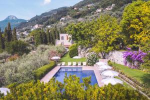 an aerial view of a house with a swimming pool with umbrellas at Residence Fondo La Campagnola in Gargnano
