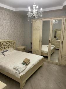 Un dormitorio con una cama grande y una lámpara de araña. en sweet home, en Tiflis