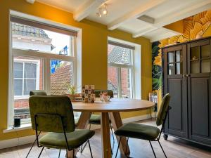 a dining room with a wooden table and chairs at Stijlvol Familie Appartement De Waegh in Dokkum