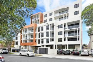 a white building with cars parked in front of it at Vogue Apartment 809 in Sydney