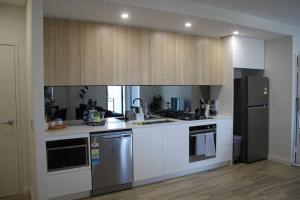 a kitchen with white counters and stainless steel appliances at Vogue Apartment 809 in Sydney