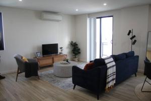 a living room with a blue couch and a tv at Vogue Apartment 809 in Sydney