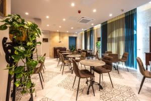 a restaurant with tables and chairs and plants at Casa Rosanna Malta B&B Adults only 16 plus in Marsaskala
