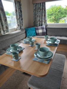 a wooden table with cups and saucers on it at The Mayflower in Millom