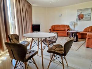 a living room with a table and chairs at Vienas po kitu in Šventoji +36 photos